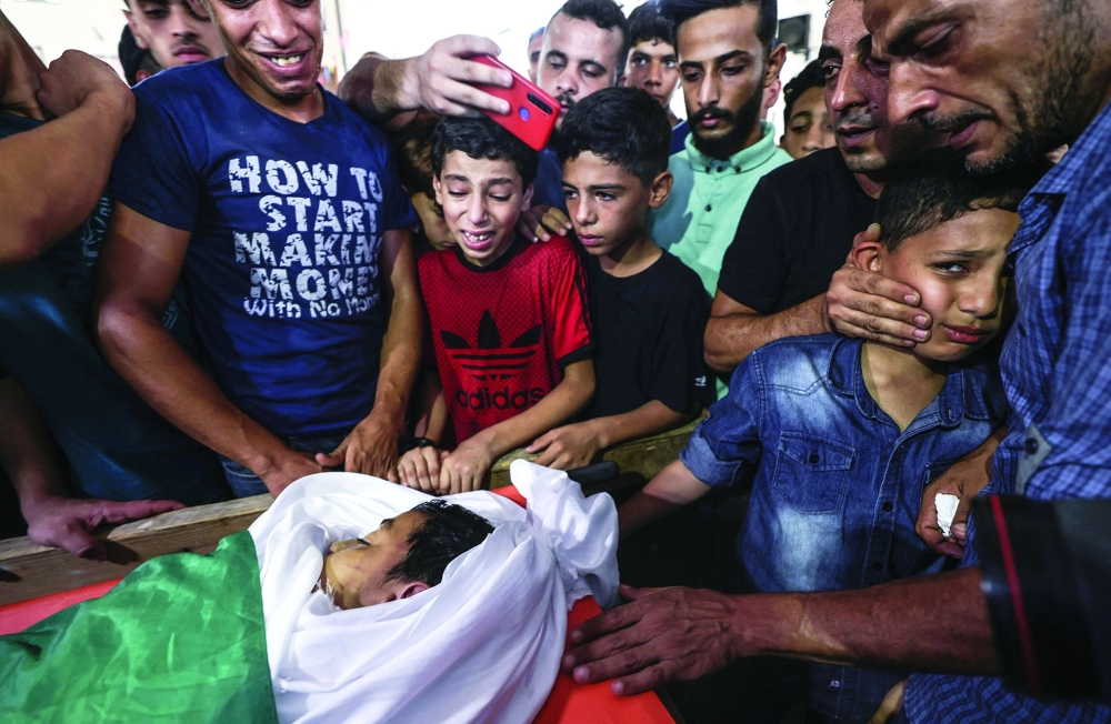 اصدقاء وأقارب الفلسطيني عمر حسن أبو النيل، 12 عاما، الذي استشهد متأثرا بجروح أصيب بها خلال احتجاج على السياج الحدودي بين إسرائيل وغزة الأسبوع الماضي. رويترز 