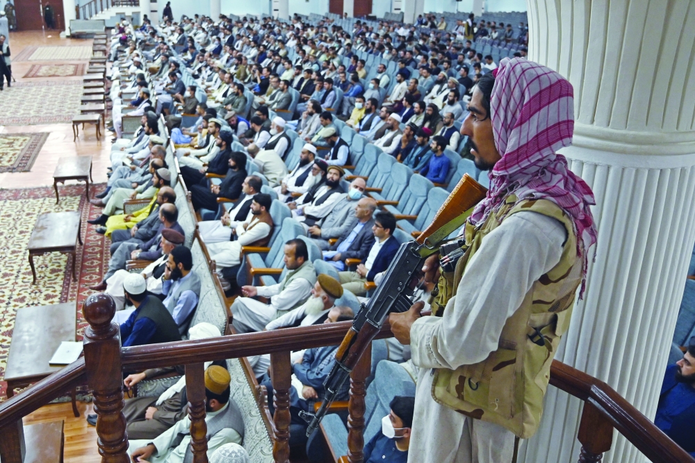  مقاتل من طالبان يقف في حراسة وزير التعليم العالي بالوكالة عبد الباقي حقاني الذي يلقي كلمة أمام تجمع خلال اجتماع تشاوري حول سياسات التعليم العالي العامة لطالبان في قاعة لويا جيرغا في كابول.أ.ف.ب