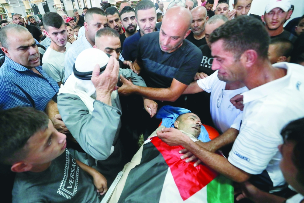 
 المشيعين يحملون جثة الشهيد الفلسطيني رائد جاد الله، الذي استشهد برصاص القوات الإسرائيلية، بالقرب من رام الله في الضفة الغربية المحتلة. رويترز 