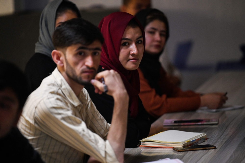 الطلاب ذكورا واناثا يحضرون فصلهم الدراسي بعد إعادة فتح الجامعات الخاصة في كابول أمس حيثترترتدي النساء الحجاب.أ.ف.ب