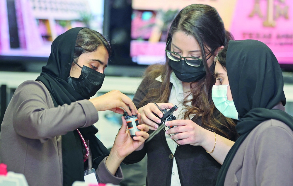  فريق فتيات الروبوتات  الأفغانيات يقمن ببناء لوحة دوائر كهربائية ، في مختبر جامعة تكساس إيه آند إم القطرية في العاصمة الدوحة حيث تم إجلاء الأعضاء التسعة من فريق الروبوتات وعدن إلى التعليم والعمل للمشاركة في مسابقة الروبوتات العالمية.أ.ف.ب