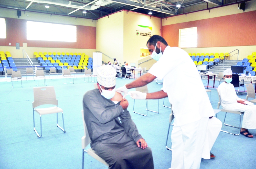 طالب يأخذ التطعيم بعبري