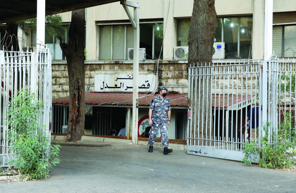 أحد أفراد الشرطة يحرس قصر العدل في بيروت  أمس.رويترز