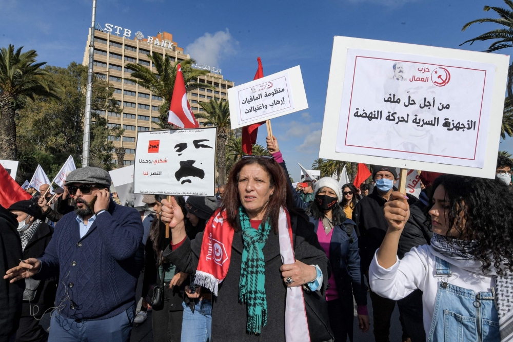 متظاهرون تونسيون في ذكرى اغتيال السياسي اليساري شكري بلعيد الذي قُتل بالرصاص خارج منزله عام 2013.   (أ ف ب)