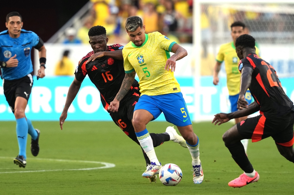 برونو جيمارايش لاعب البرازيل في محاولة لتخطي مدافعي كولومبيا  «رويترز»