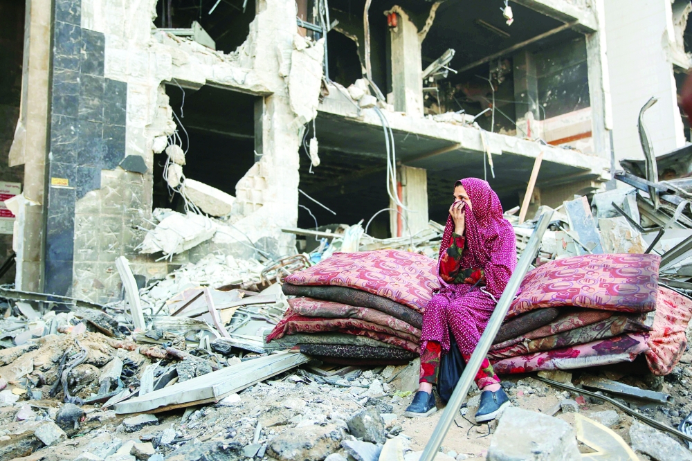 امرأة فلسطينية تجلس وسط أنقاض مستشفى الشفاء في غزة بعد انسحاب الجيش الإسرائيلي في 1 أبريل 2024