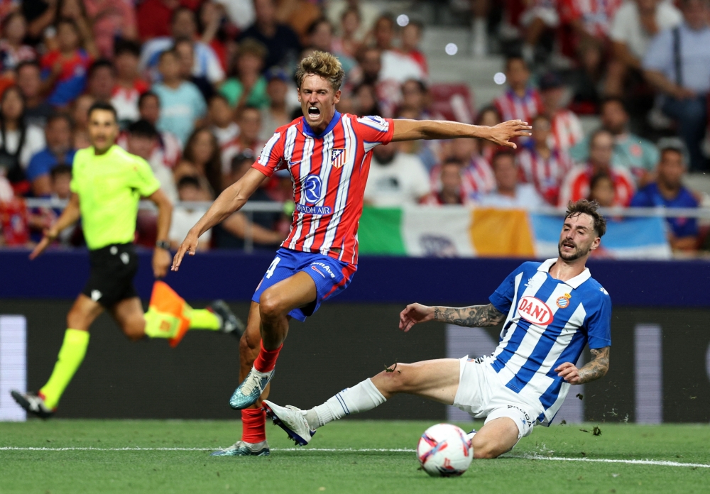 فرناندو كاليرو لاعب إسبانيول يتنافس على الكرة مع ماركوس يورينتي لاعب أتلتيكو مدريد 