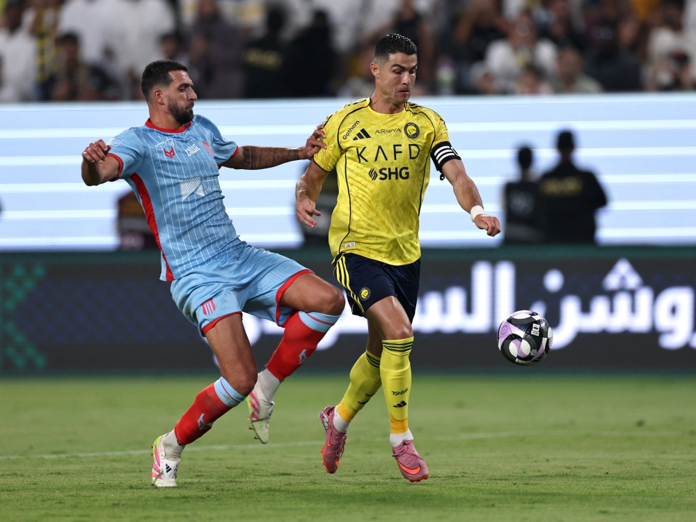 كريستيانو رونالدو لاعب النصر يمر من لاعب الرياض يوان باربيت لاعب الرياض «رويترز»
