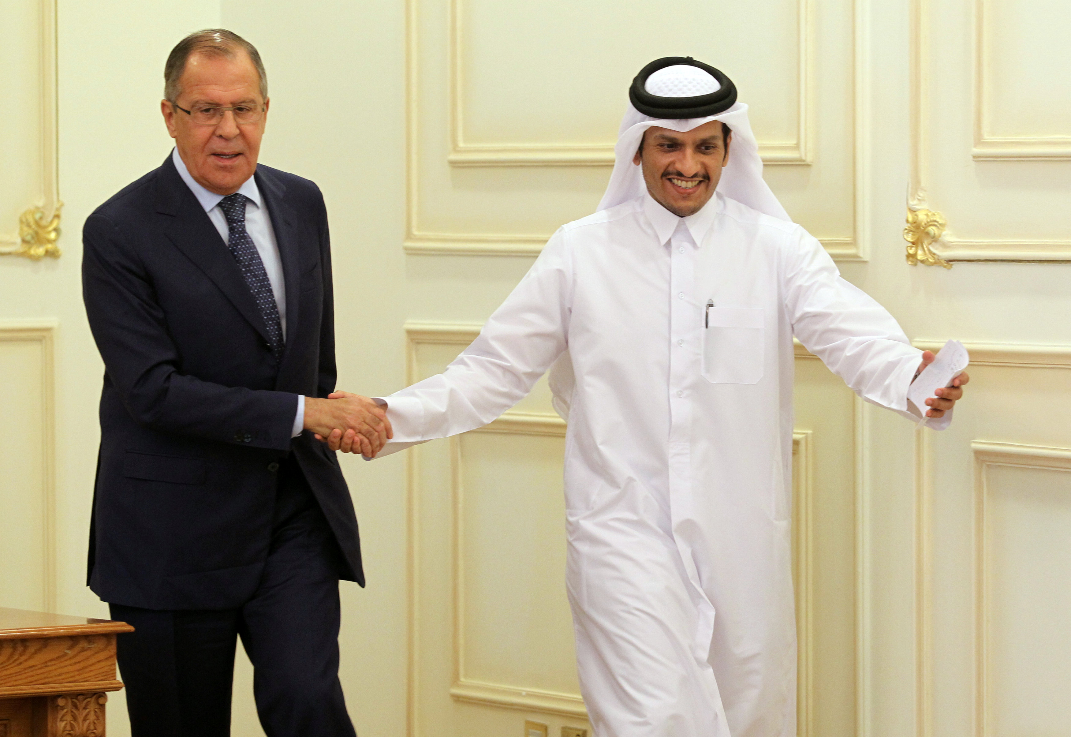 Qatar's foreign minister Sheikh Mohammed bin Abdulrahman al-Thani shakes hands with Russia's foreign minister Sergey Lavrov after a joint news conference in Doha