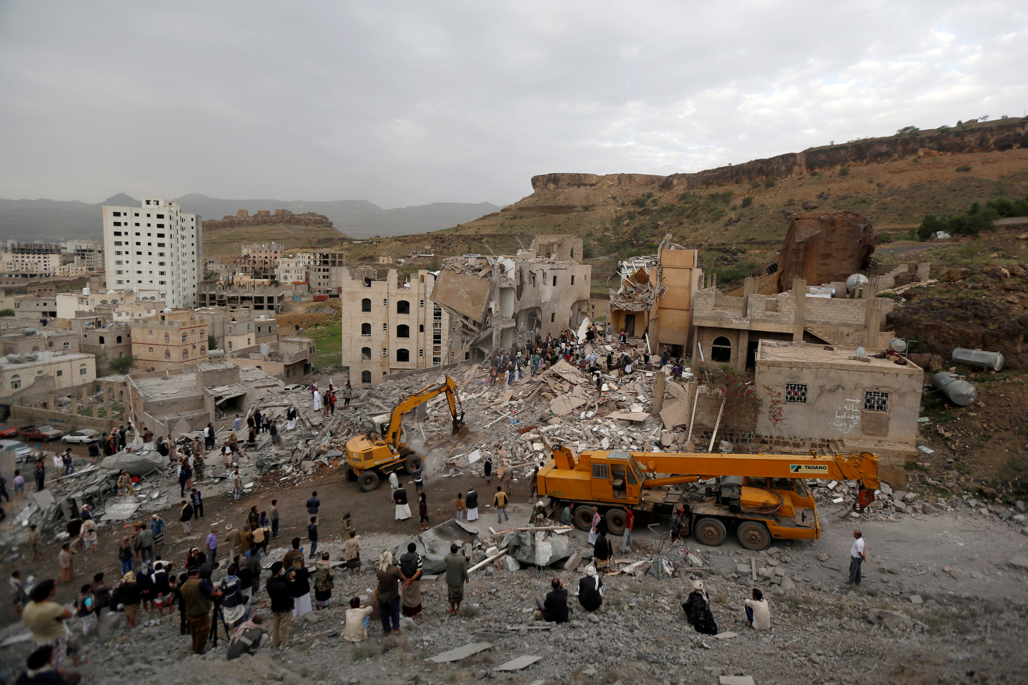 People search under rubble of a house destroyed by a Saudi-led air strike in Sanaa
