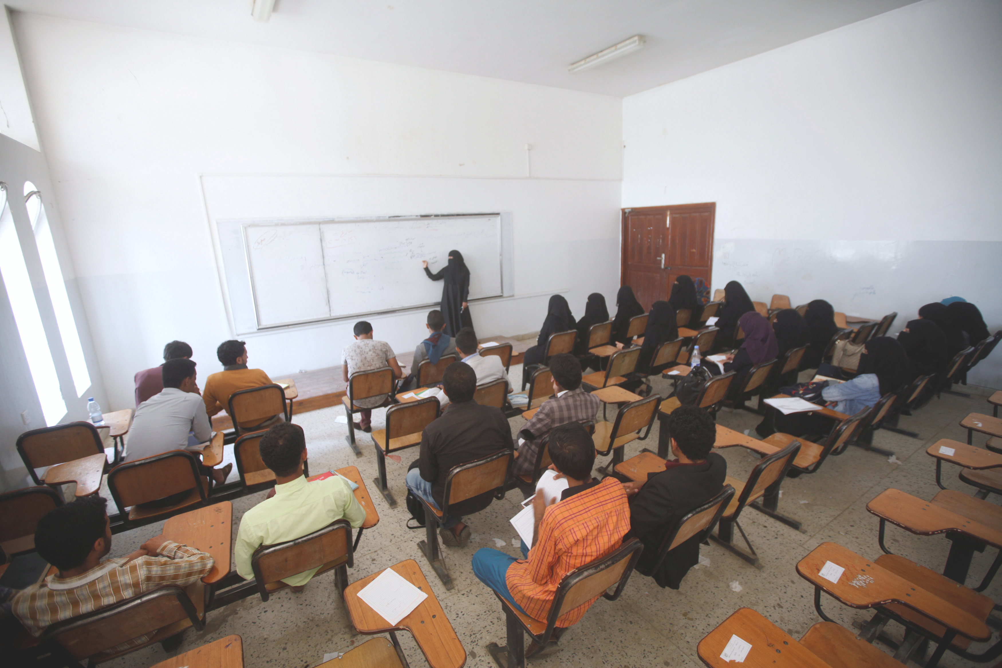Students listen to a professor during a class at Sanaa University in Sanaa