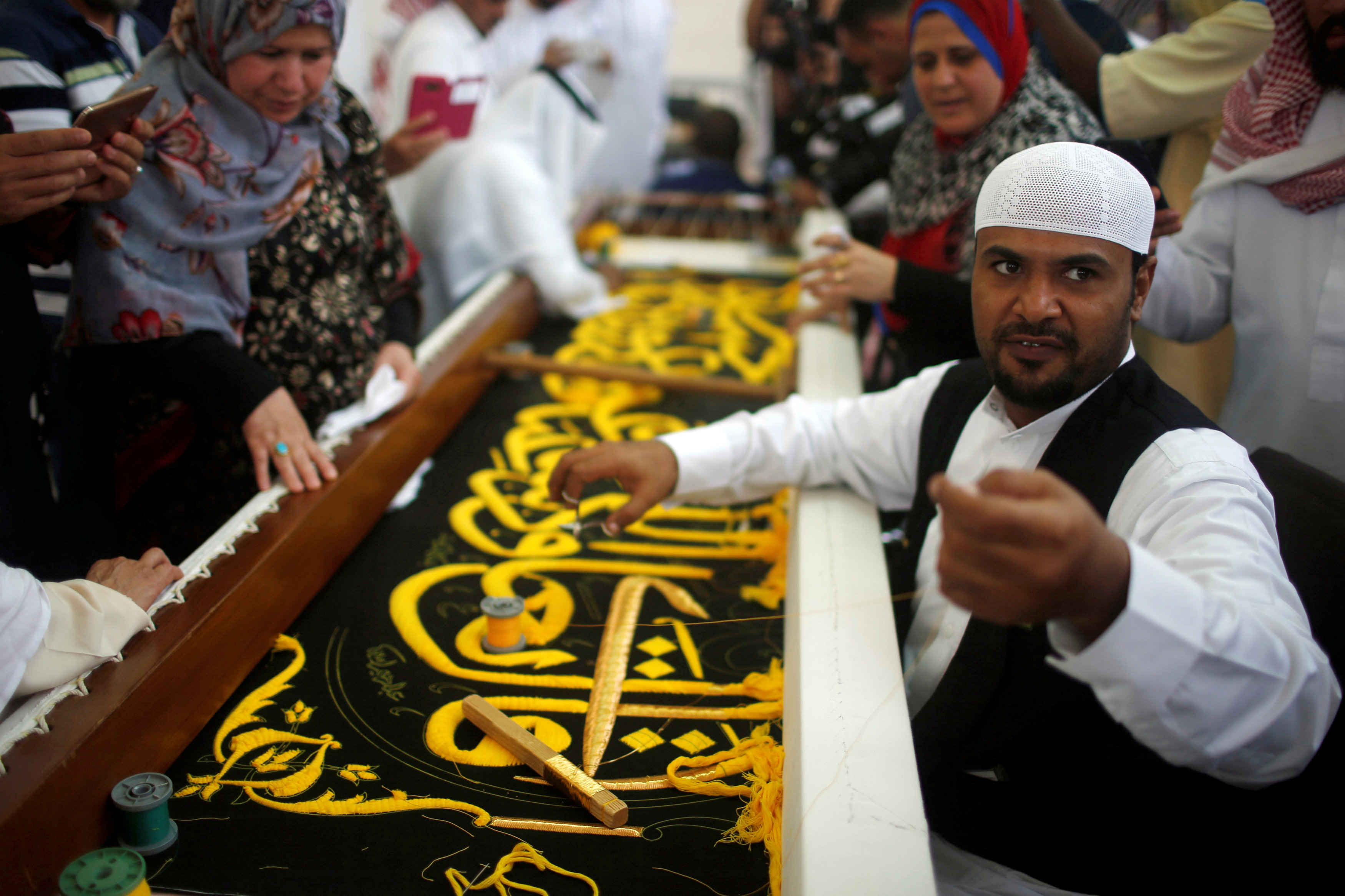A man embroiders the Kiswa, a silk cloth covering the Holy Kaaba, ahead of the annual haj pilgrimage, at a factory in the holy city of Mecca
