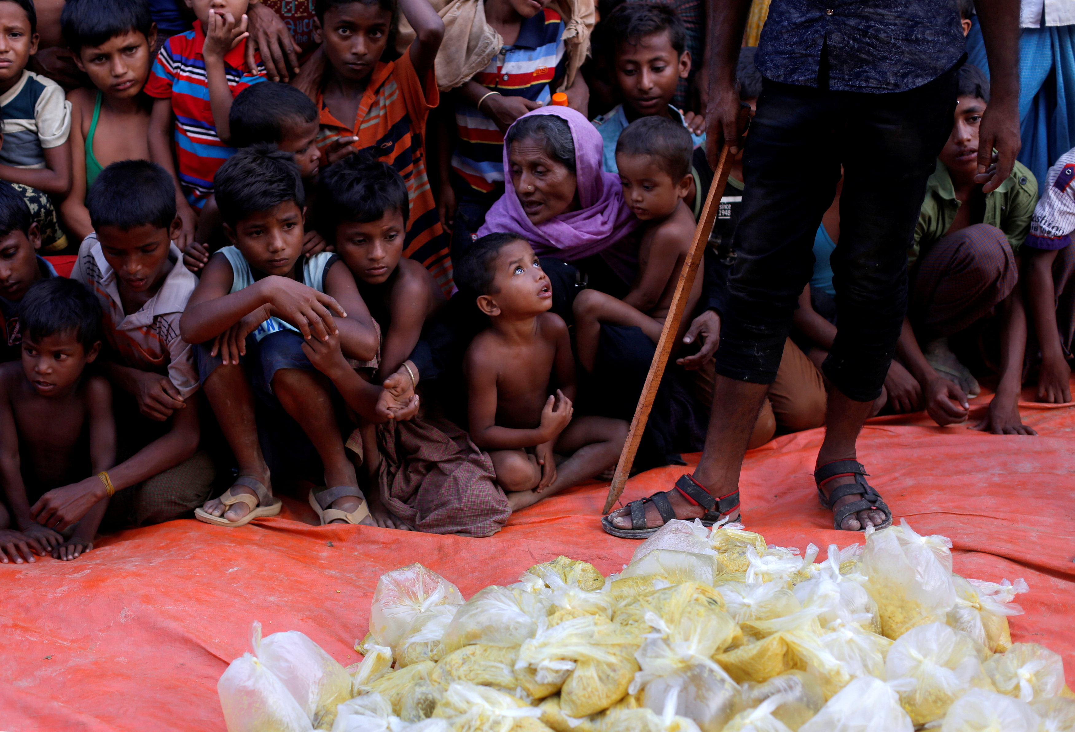 Rohingya refugees wait for the food to be distributed by local organisation outside a mosque in Cox's Bazar