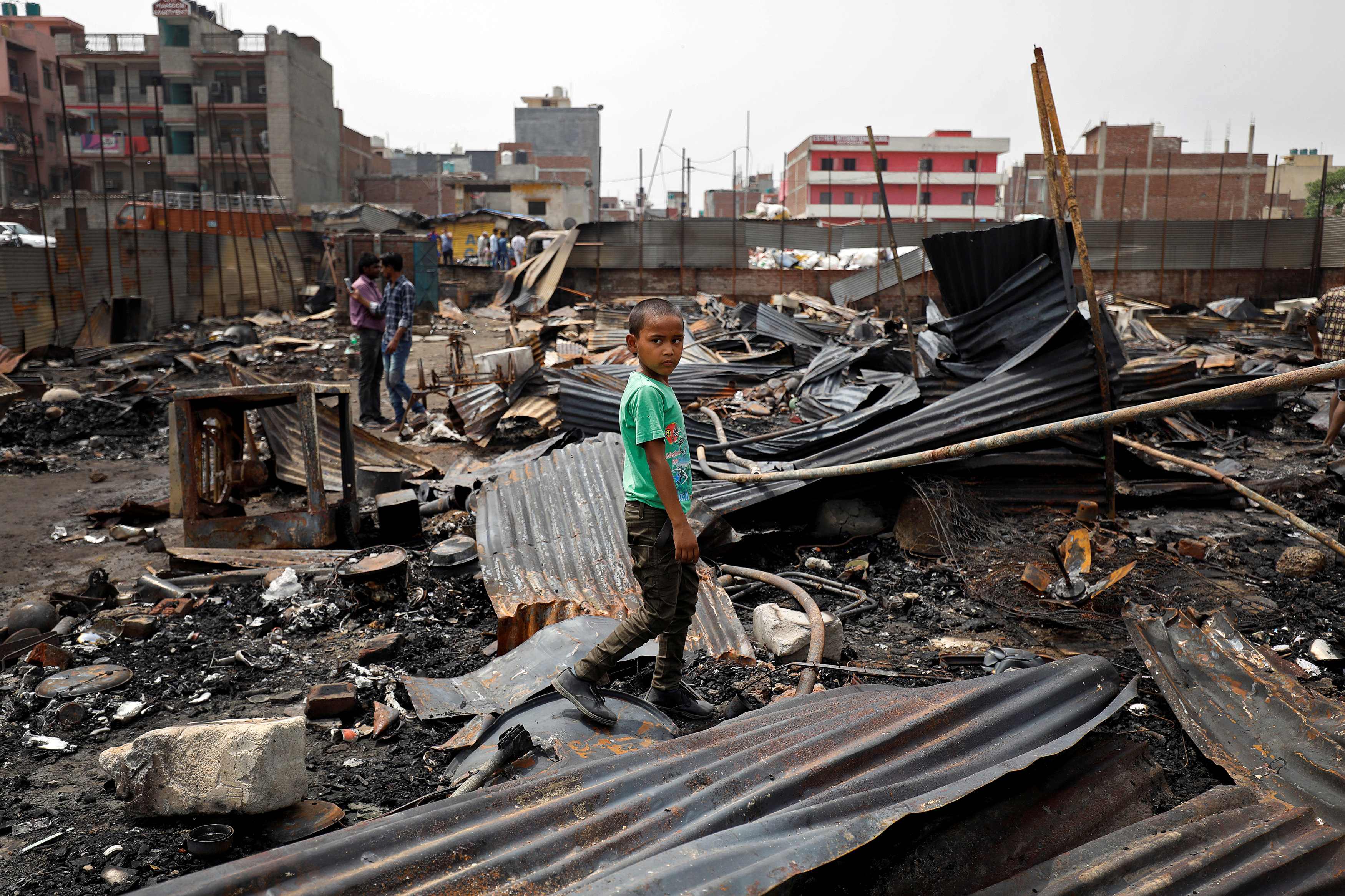 A boy from Rohingya community walks on the debris after a fire broke out in the camp in New Delhi