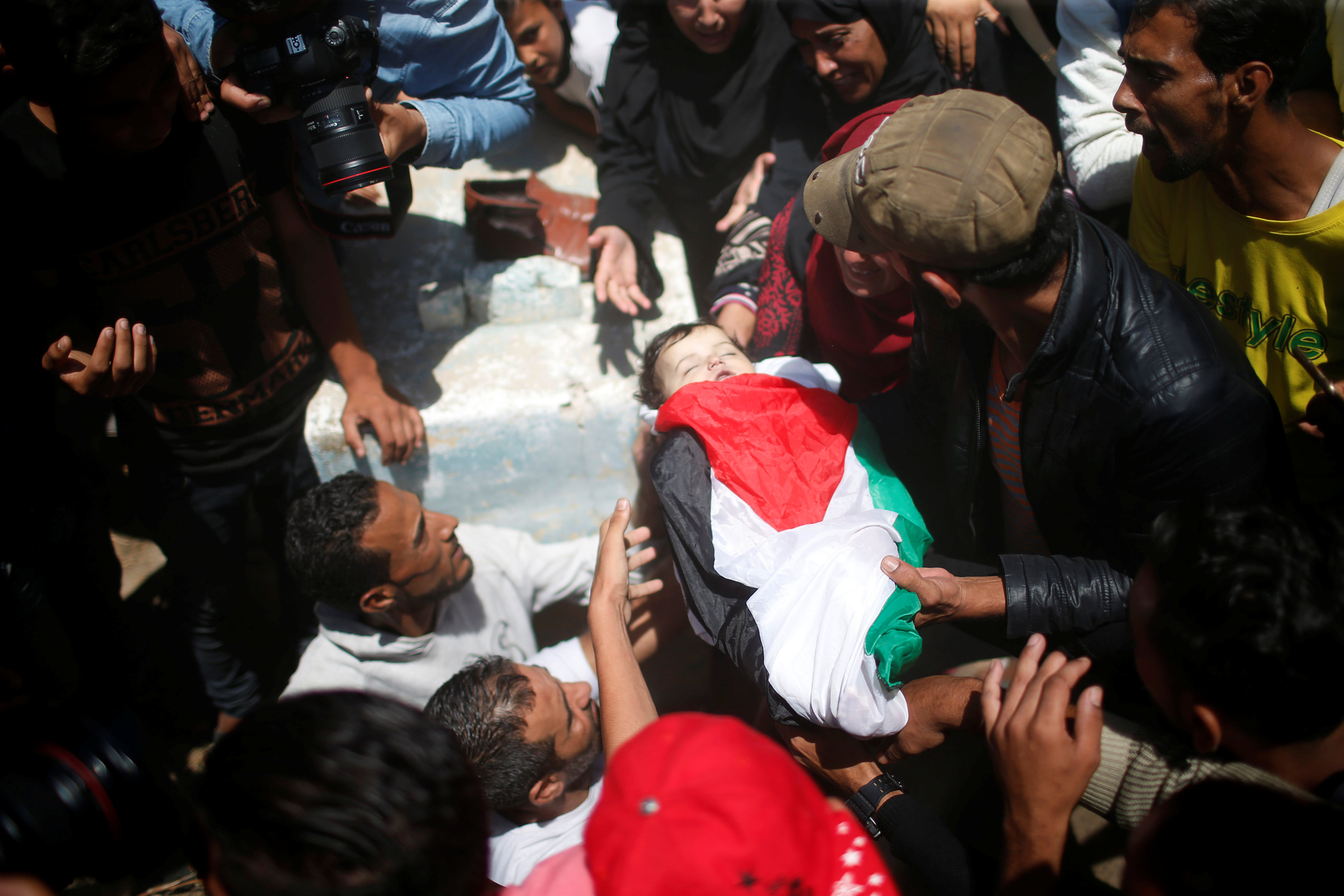 Mourners bury the body of eight-month-old Palestinian infant Laila al-Ghandour, who died after inhaling tear gas during a protest against U.S embassy move to Jerusalem at the Israel-Gaza border, during her funeral in Gaza City