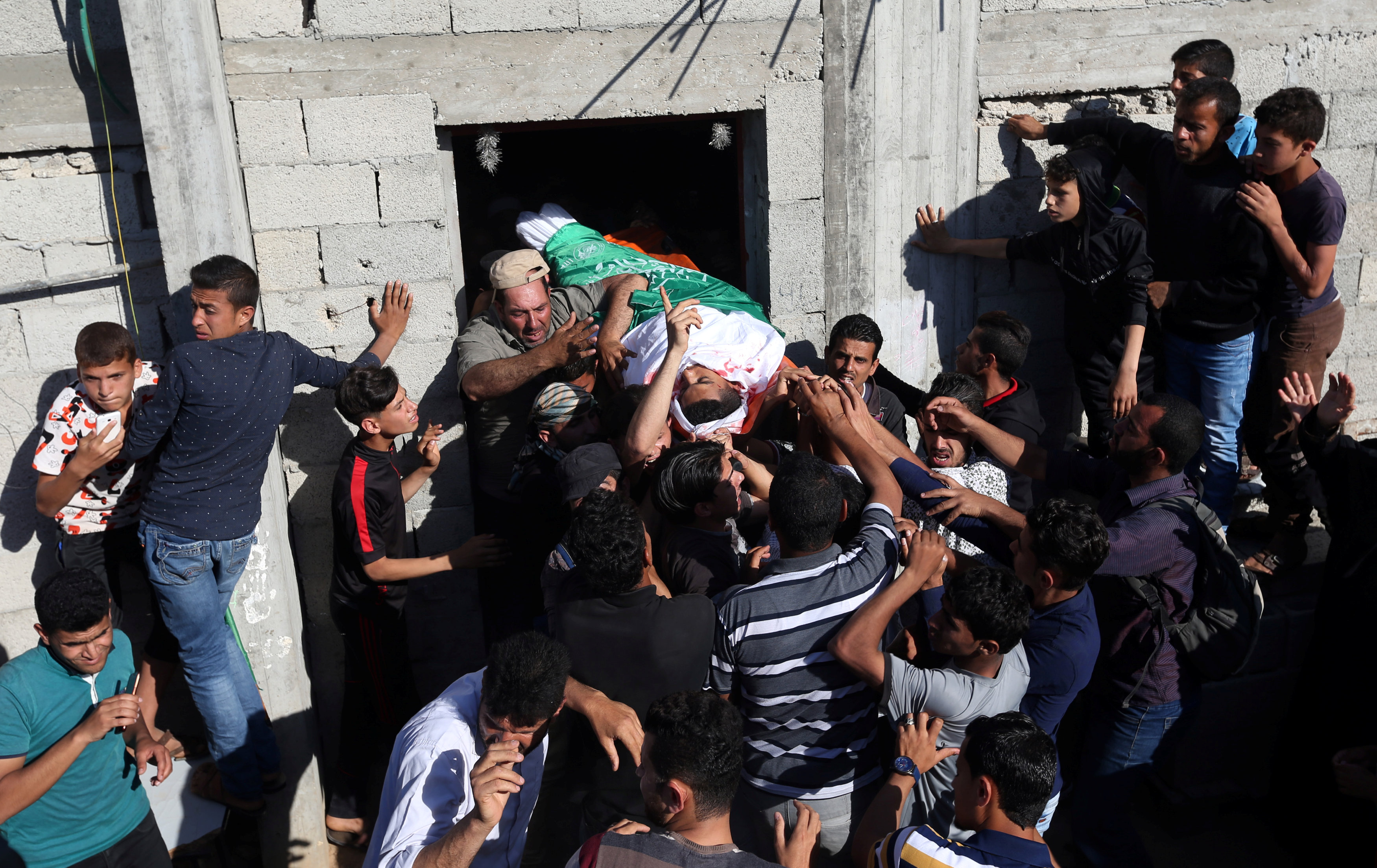 Mourners carry the body of a Palestinian, who was killed during a protest at the Israel-Gaza border, during his funeral in Khan Younis in the southern Gaza Strip