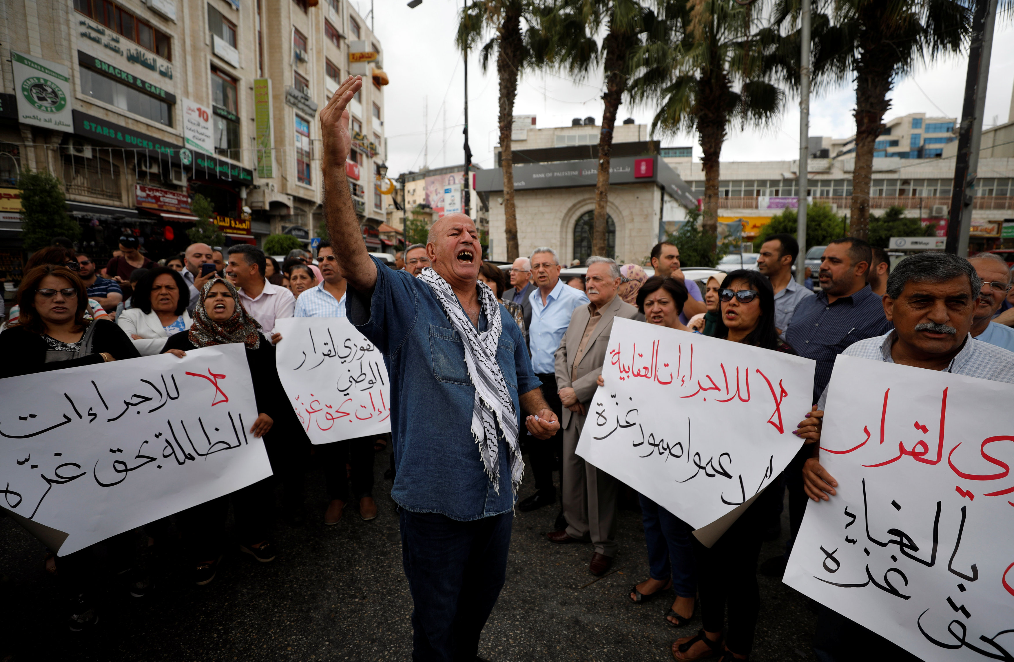 Palestinians take part in a protest demanding to lift the sanctions on Gaza Strip, in Ramallah, in the occupied West Bank