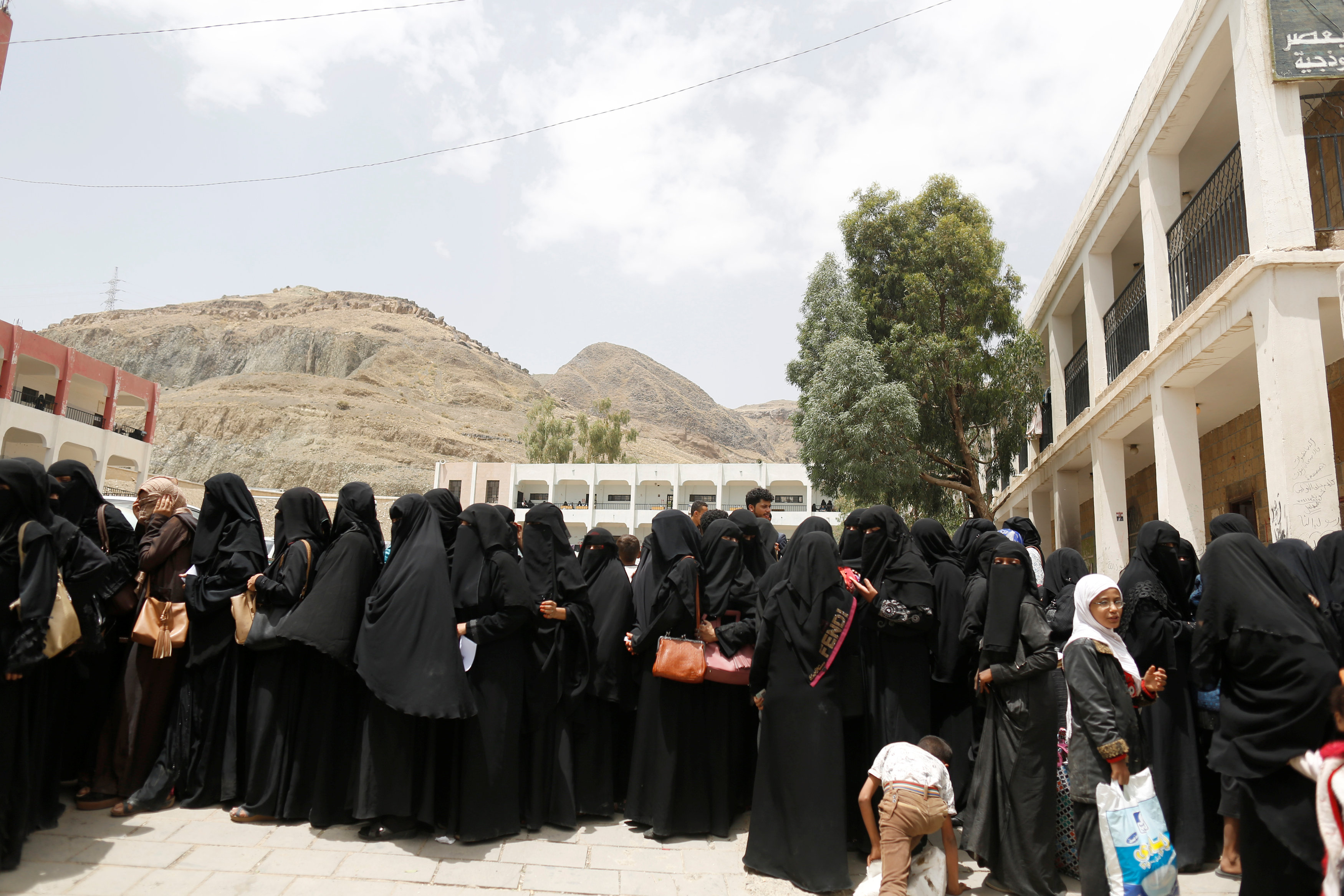 Women displaced by the fighting in the Red Sea port city of Hodeidah queue to register in a school allocated for IDPs in Sanaa, Yemen