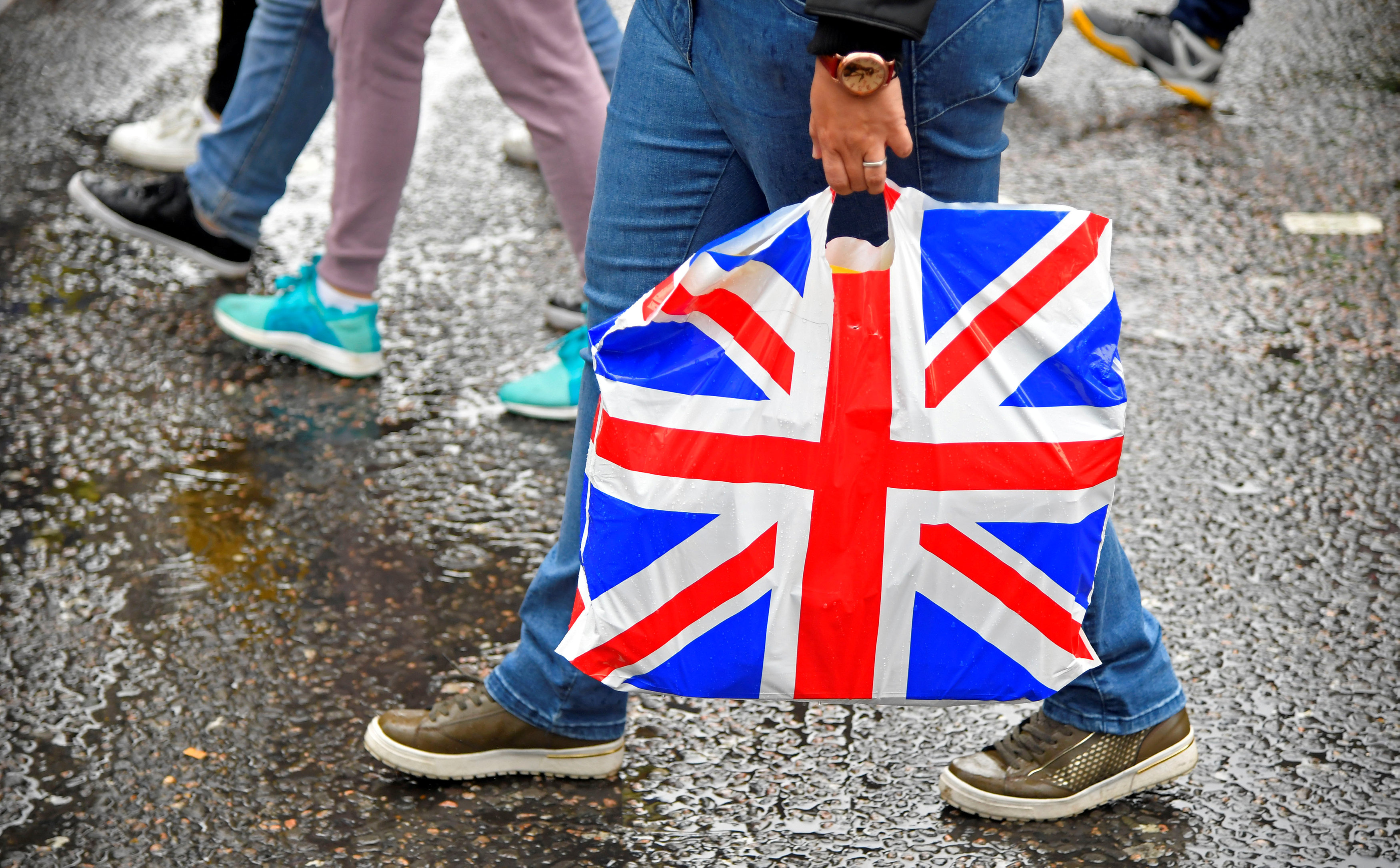 FILE PHOTO: A pedestrian carries a British union flag design plastic bag in Leicester Square in London, Britain