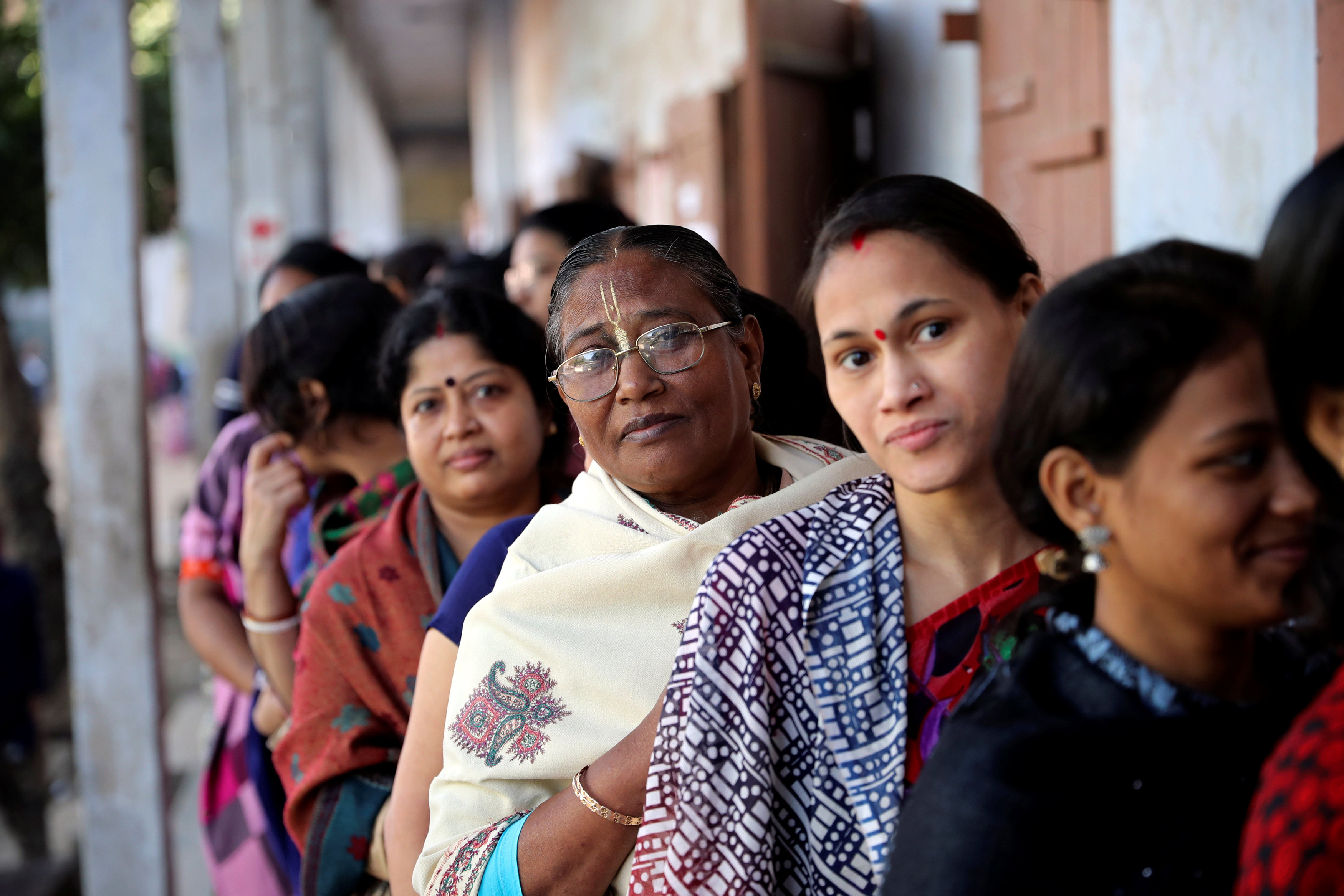 Hindu voters wait to cast their vote outside a voting center during the general election in Dhaka
