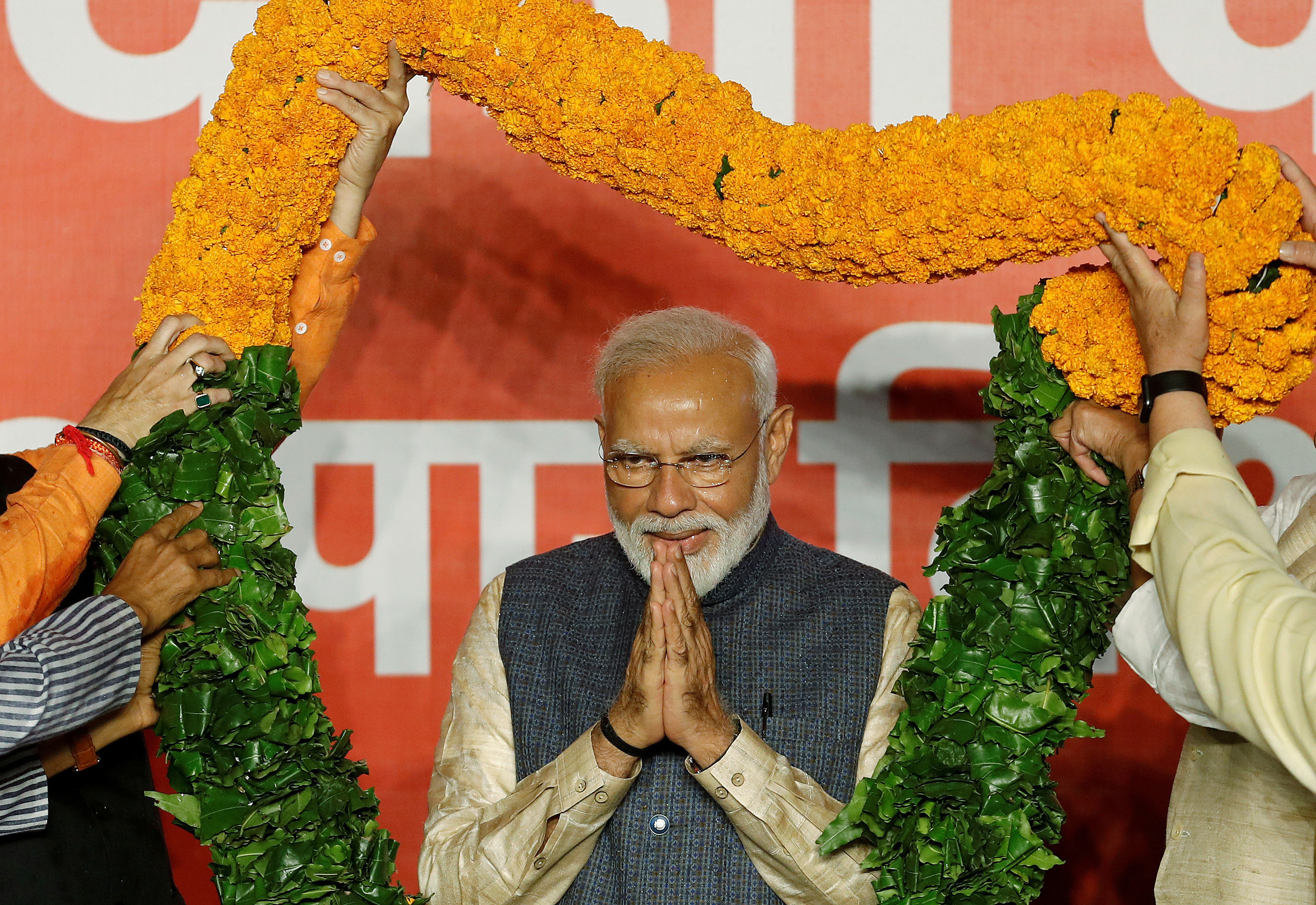 FILE PHOTO: Indian Prime Minister Narendra Modi gestures as he is presented with a garland by Bharatiya Janata Party (BJP) leaders after the election results in New Delhi