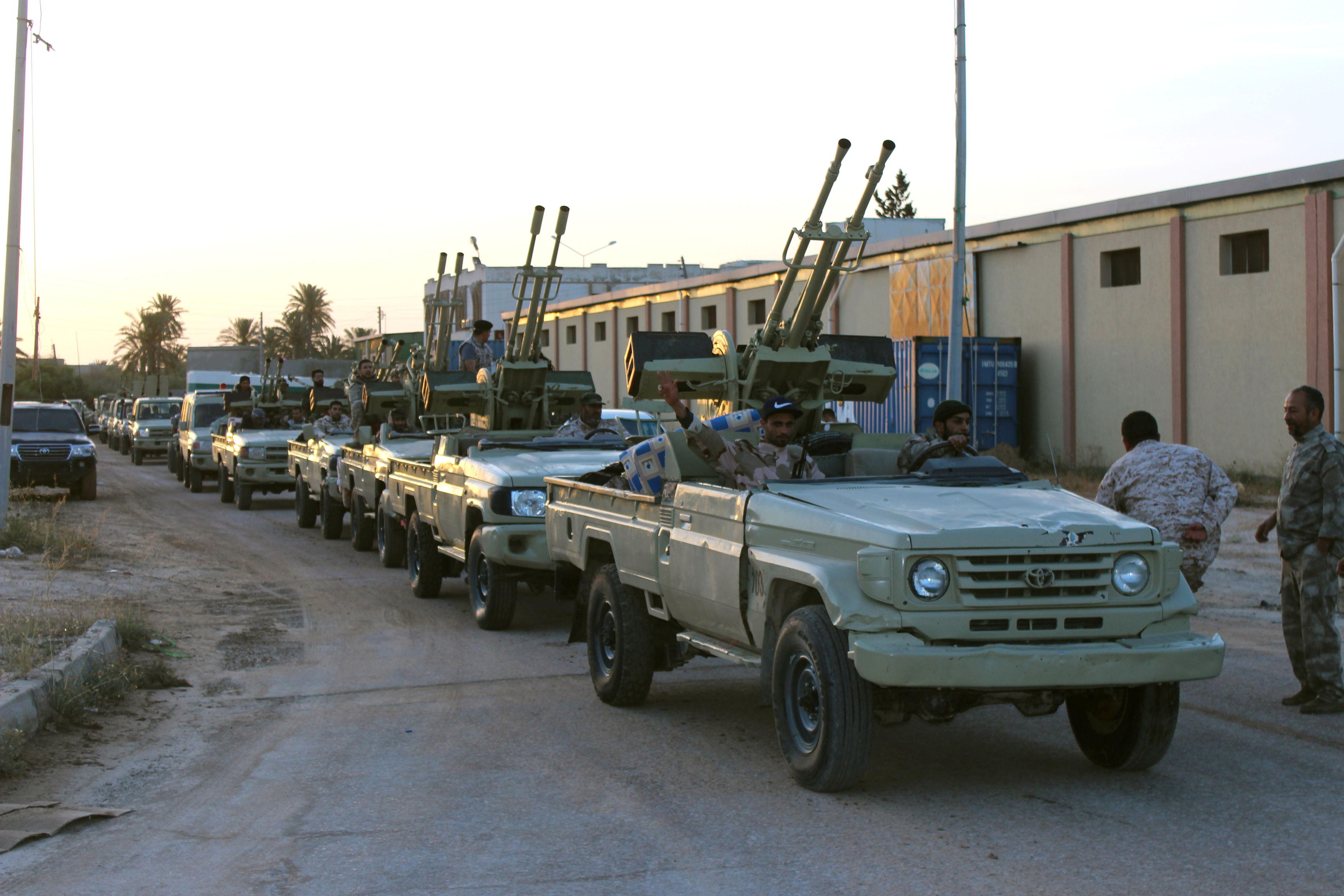 Military vehicles of members of the Libyan government forces head out to the front line in Tripoli
