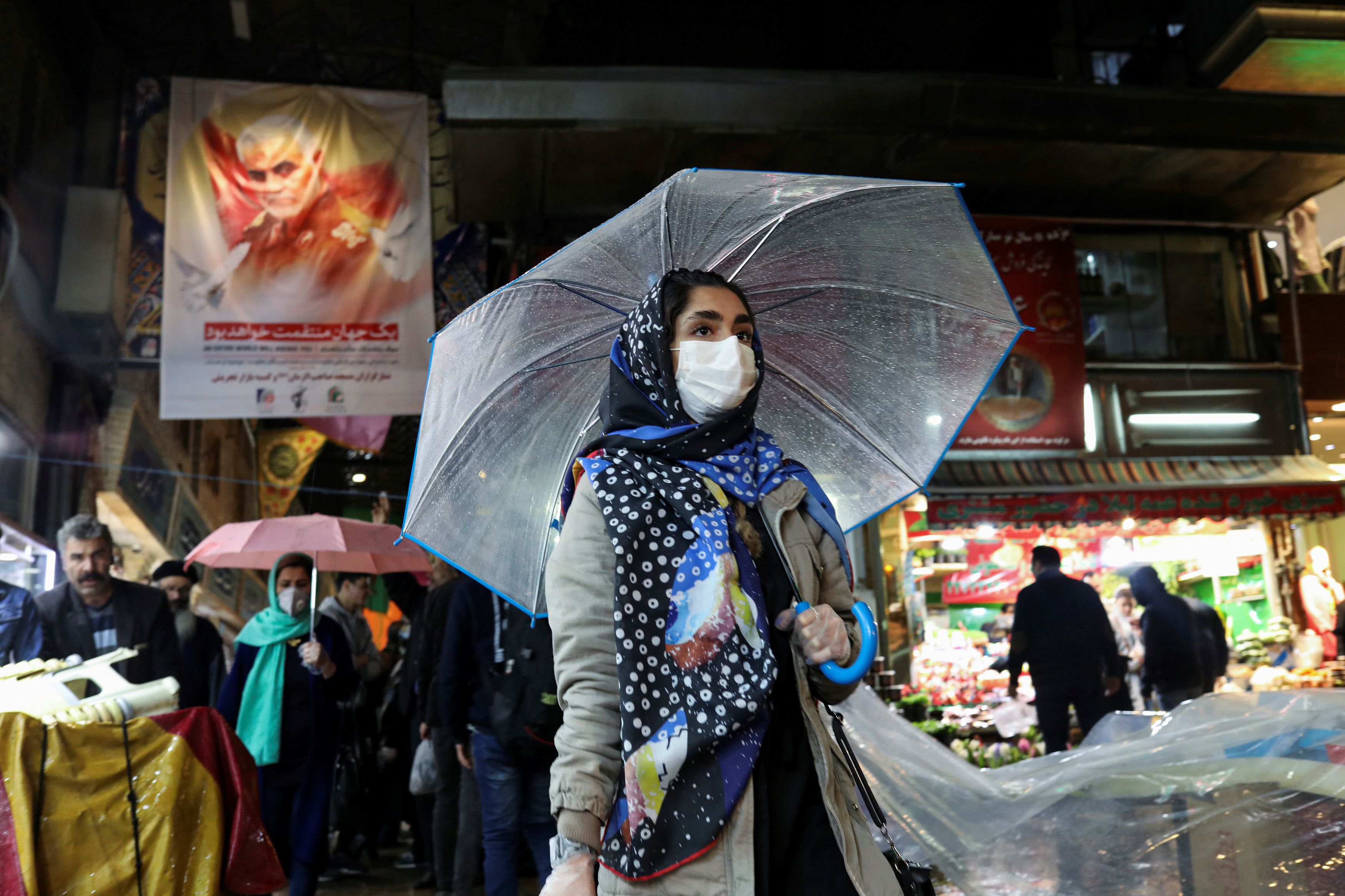 An Iranian woman wears a protective face mask and gloves, amid fear of coronavirus disease (COVID-19), as she walks at Tajrish market, ahead of the Iranian New Year Nowruz, March 20, in Tehran