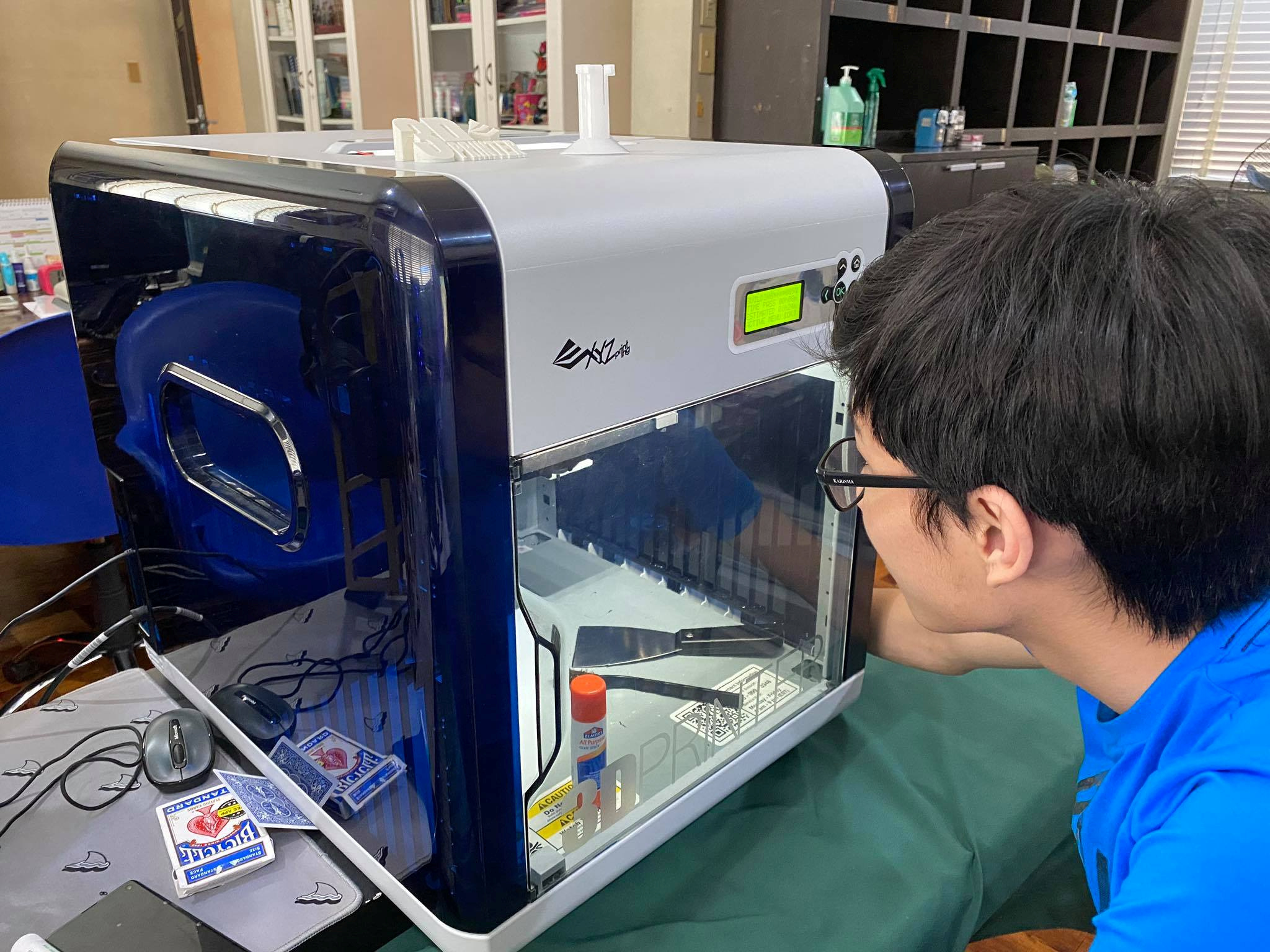 Filipino student Marcus Chu looks at his 3D printer while working on printing frames for his face shields at his home in Manila