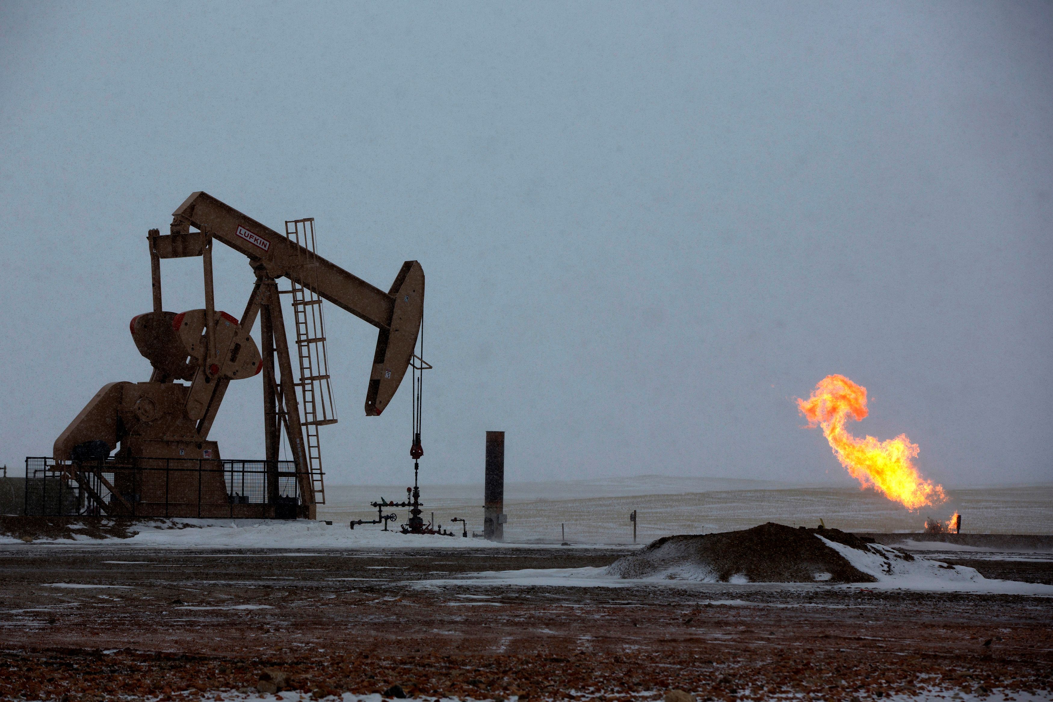 FILE PHOTO: Natural gas flares are seen at an oil pump site outside of Williston