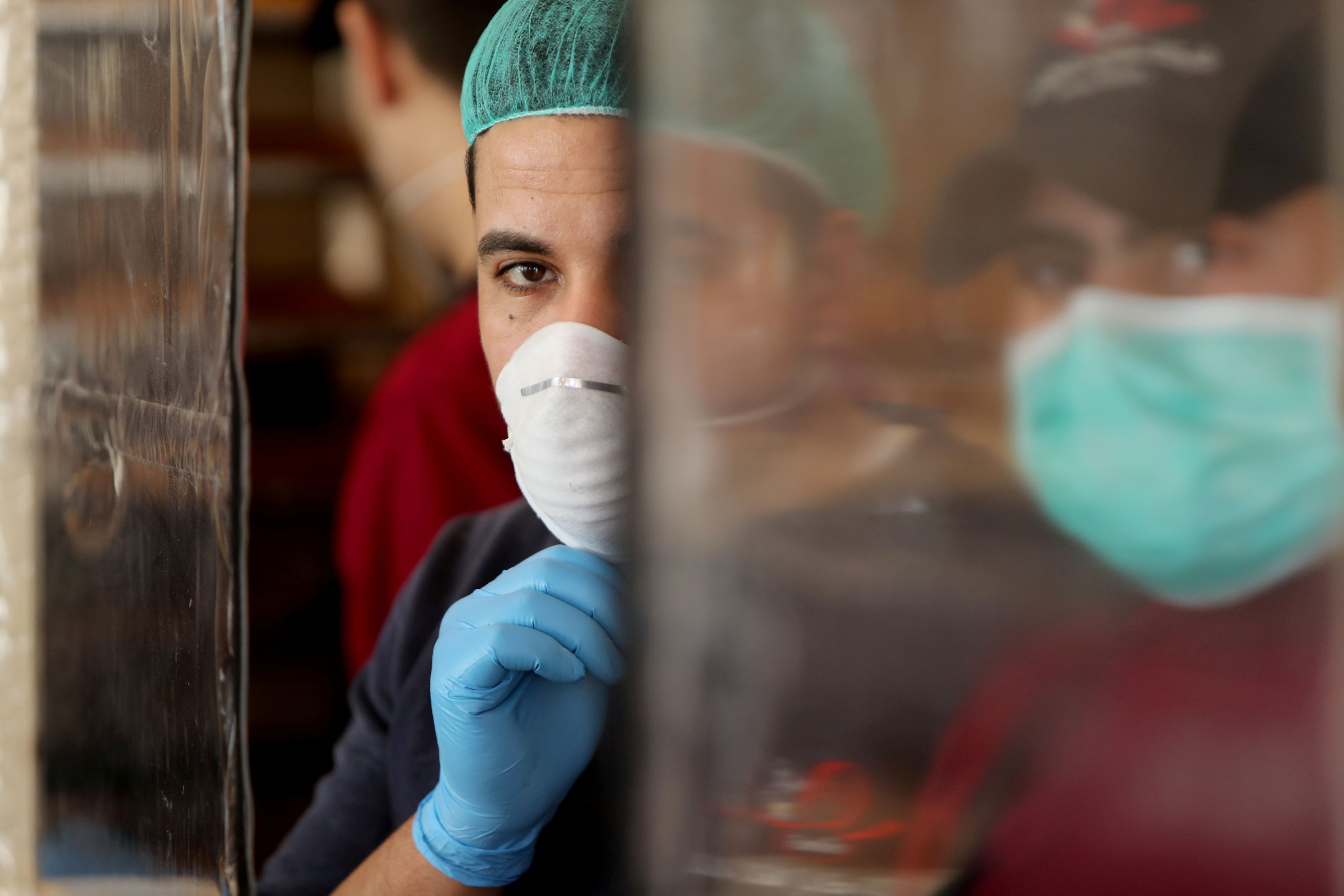 FILE PHOTO: Palestinians, wearing masks as a preventive measure against the coronavirus disease, work in a bakery in Gaza City