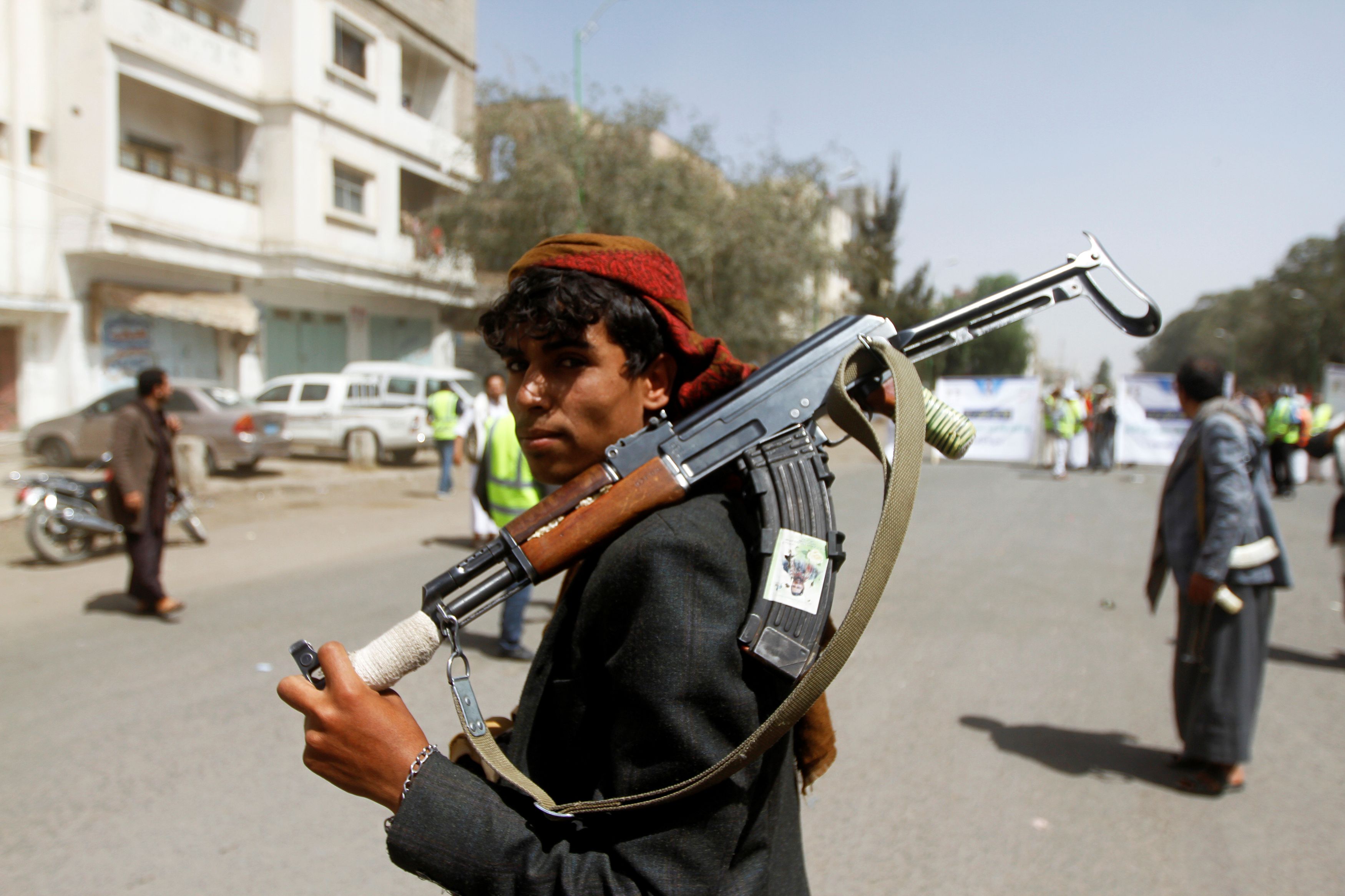 A Houthi supporter looks on as he carries a weapon during a gathering in Sanaa