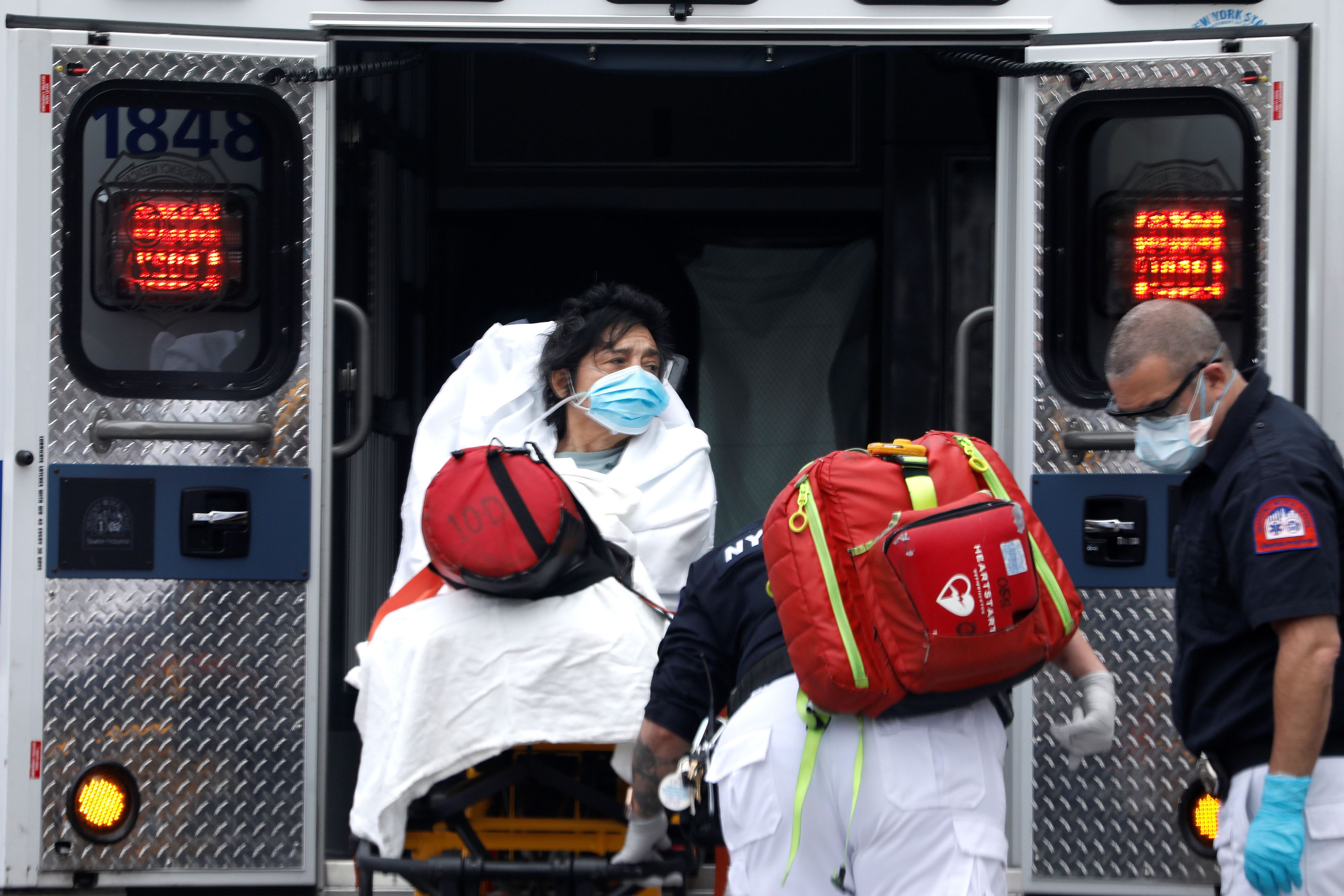 Woman loaded into ambulance in Harlem neighbourhood of Manhattan during outbreak of coronavirus in New York