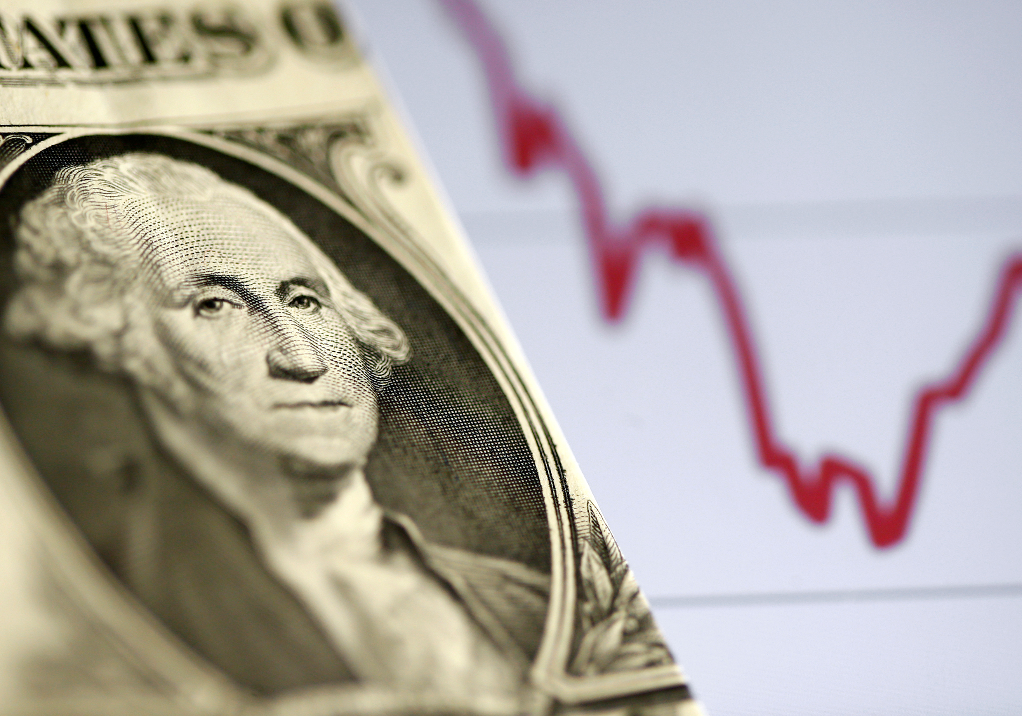FILE PHOTO: A U.S. dollar note is seen in front of a stock graph in this picture illustration