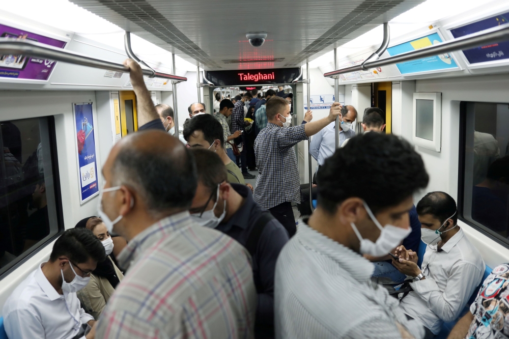 FILE PHOTO: Iranians wearing protective face masks ride the metro, following the outbreak of the coronavirus disease (COVID-19), in Tehran