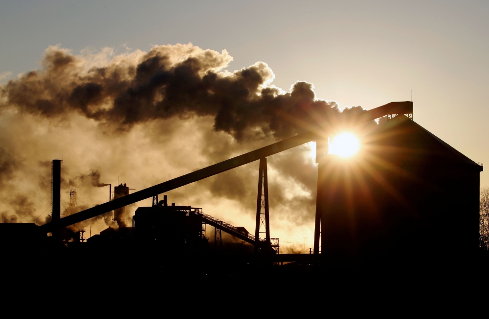 FILE PHOTO: The sun appears behind a Tereos sugar factory in Escaudoeuvres