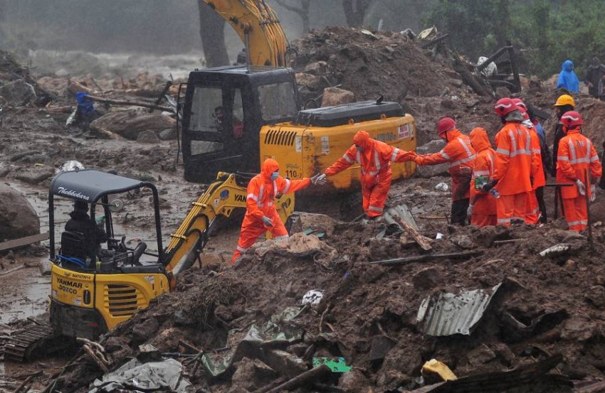 Rescue workers look for survivors at the site of a landslide during heavy rains in Idukki