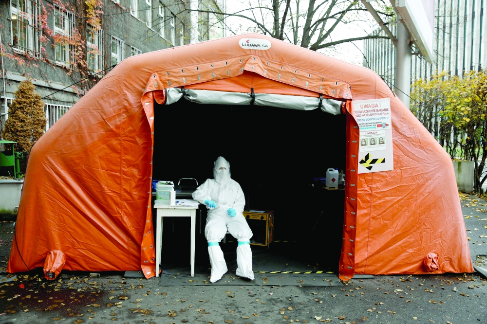 A health worker in protective suit waits for people at a test center in Warsaw