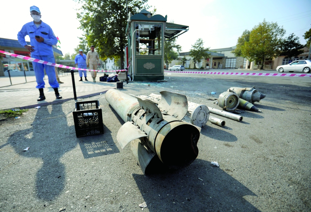 An Azeri investigator stands near fragments of ammunition following shelling in Barda