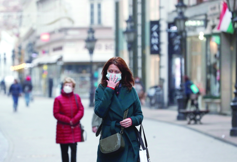 People wearing protective face masks walk in downtown Budapest