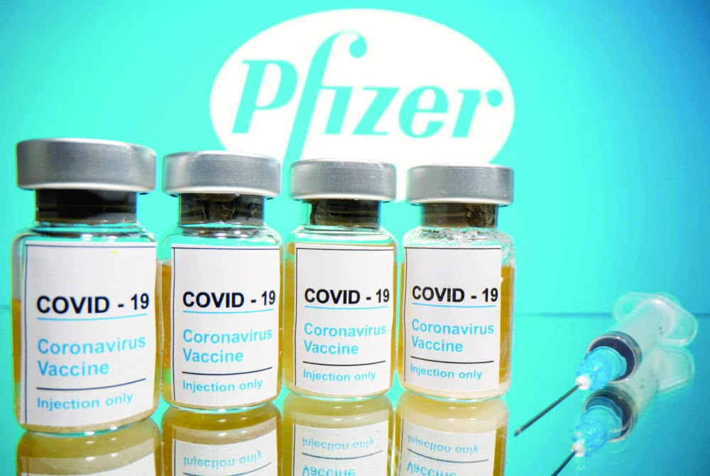 FILE PHOTO: Vials and medical syringe are seen in front of Pfizer logo in this illustration