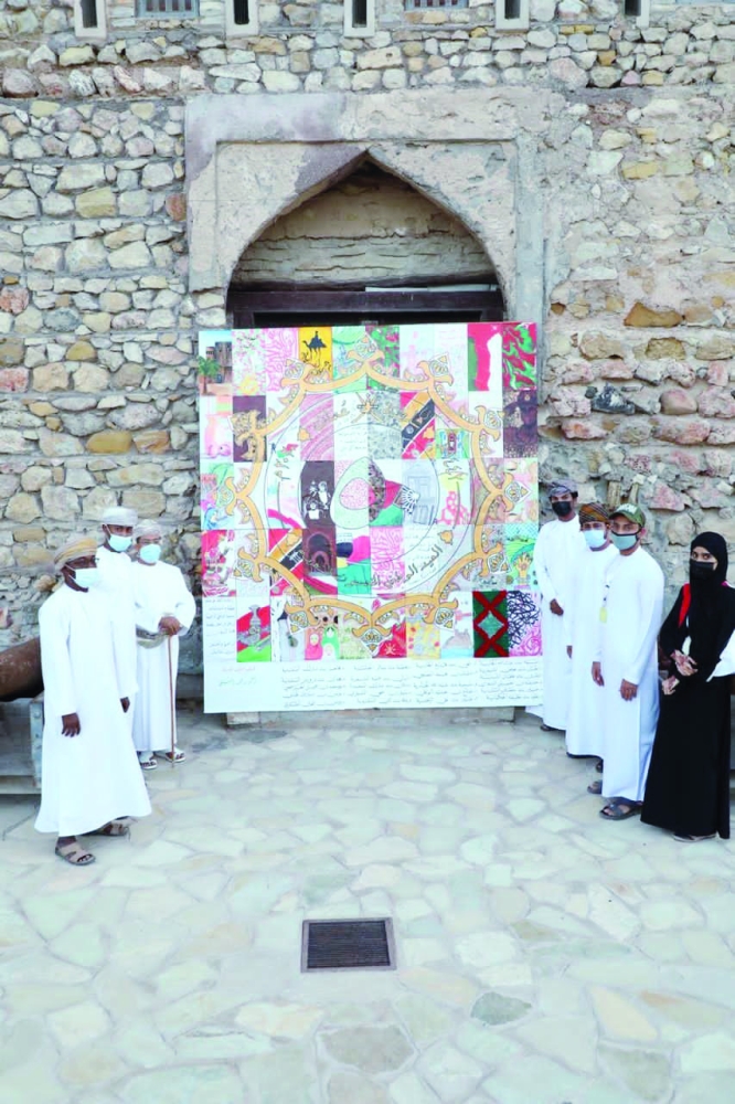 المشاركون أمام الجدارية الفنية