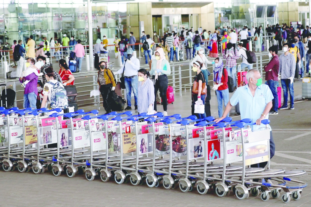 FILE PHOTO: An airport staff member pushes trolleys at Mumbai's airport after the Indian government allowed domestic flight services to resume